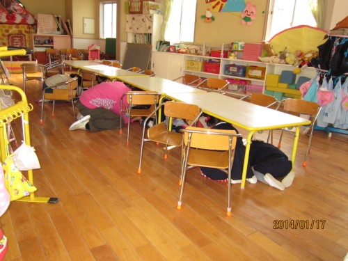 机の下で頭を守っています。 机の下で頭を守っています。