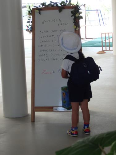 ボードに書かれたメッセージを一生懸命に読む年長児