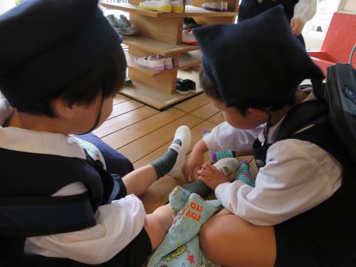 上靴を履くお手伝いをする年長さん。 上靴を履くお手伝いをする年長さん。